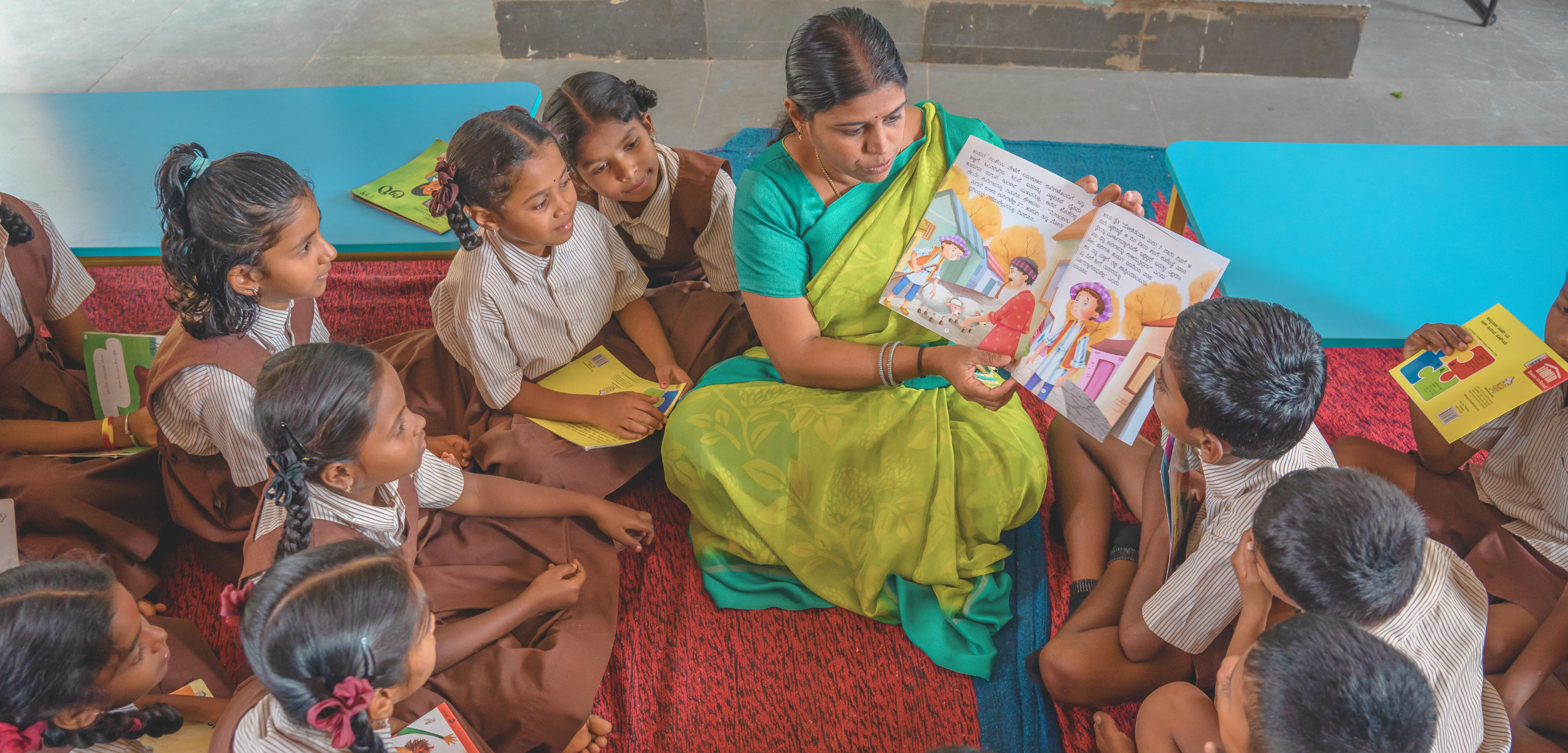 Literacy interventions, a Room to Read educator in India reads a storybook aloud to children