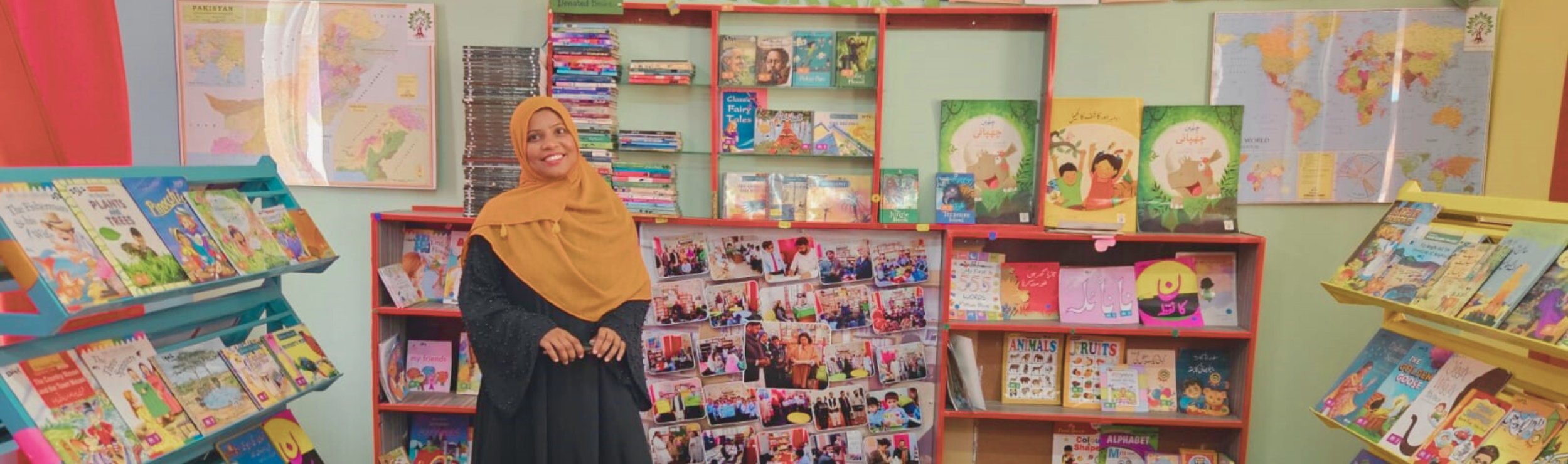 Education in Pakistan, an educator smiling in a colorful Room to Read library